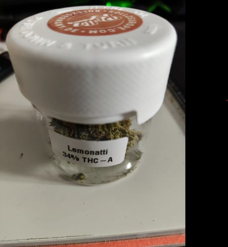 Customer's glass jar of THC-A 34% Flower Lemonatti, showing the green buds inside.