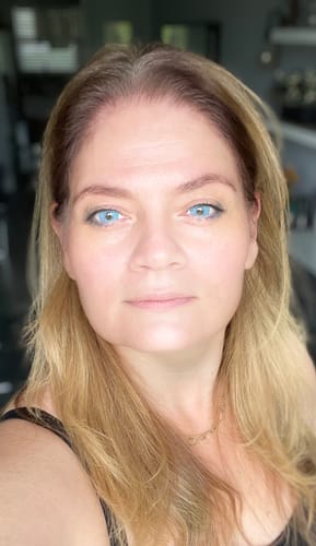 Reviewer showing off the vibrant Mule Blue Colored Contact Lenses in a bright, indoor setting.