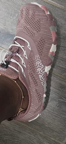 Close-up of a customer's foot wearing the dusty pink Smart II Barefoot Shoe with a patterned sole.