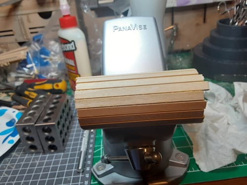 Cliente construyendo la caldera de madera de la maqueta del Tren Rocket, sujeta en un tornillo de banco.