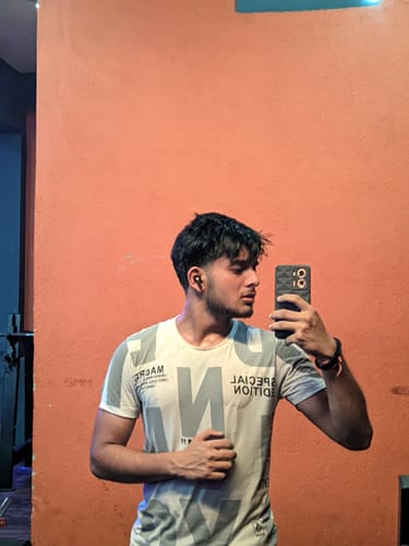 Reviewer taking a mirror selfie in a gym, showing their physique after a workout.