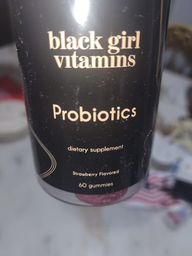 Close-up of the customer's black bottle of Black Girl Vitamins Probiotics, showing the strawberry flavored gummies.