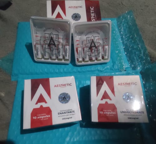 Cliente muestra varias cajas y ampollas de productos Aesthetic Labs, incluyendo el BoldX 300, sobre un empaque de burbujas.