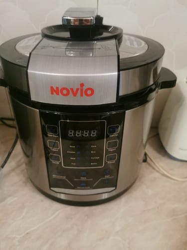 A customer's Novio SteelCook multicooker, in stainless steel and black, sitting on a kitchen counter with the digital display visible.