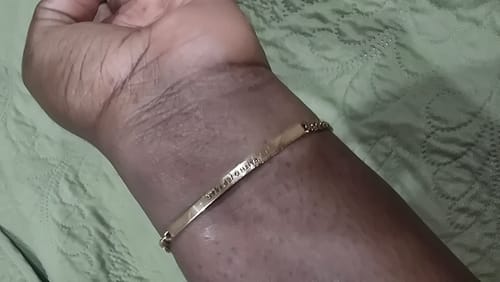 Close-up of a customer wearing the gold Women's Chain Bracelet with an engraved bar on their wrist.