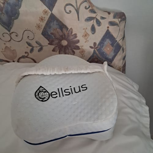Coussin orthopédique pour genoux Cellsius d'un client, posé sur un lit.