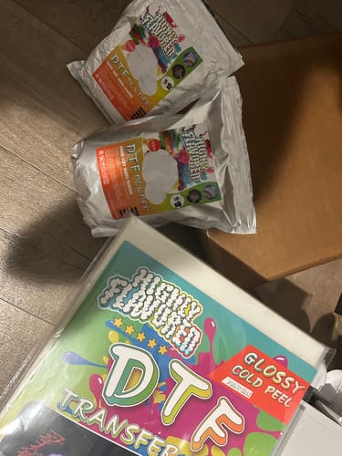 Customer's two bags of DTF Super Soft Powder resting on a wooden floor.