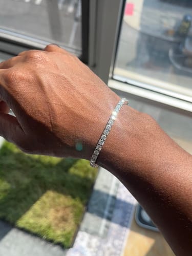 Customer's wrist wearing the shiny VVS Moissanite Tennis Bracelet in bright sunlight.