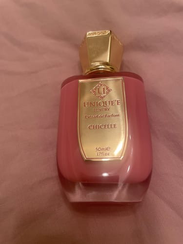 Recensore mostra il flacone rosa di Chicelle extrait de parfum con l'etichetta e il tappo dorati.