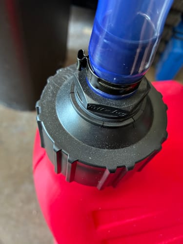 Customer's close-up of a black lid on a red jug, showing a small crack near the hose clamp.