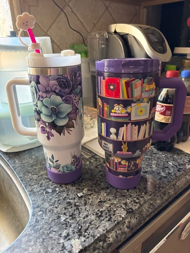 Customer shows two purple Bumper Buddy protectors on a floral travel mug and a library-themed travel mug.