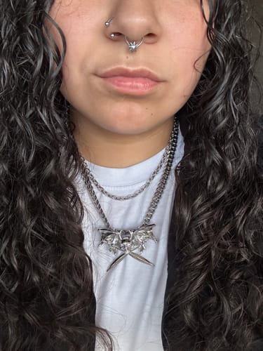 Close-up of a reviewer wearing the Born Hard Pendant on a thick chain, layered with a thinner chain.