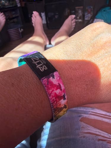 Close-up of a reviewer wearing the colorful Until We Meet Again Dog Bracelet on their wrist.