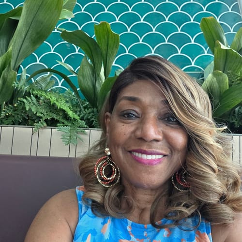 A reviewer smiles, showing their dewy complexion after using the Deep Collagen Cream.