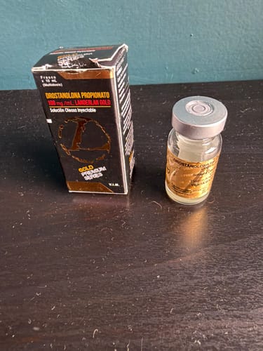 Un cliente muestra el vial de Masteron 100 mg Landerlan junto a su caja negra y dorada.