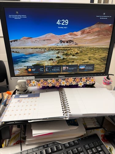 Reviewer's open Nancy Planner on a desk, showing the monthly and weekly split-page layout in their workspace.
