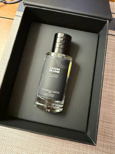 Customer's Lilium Blume Eau de Parfum bottle inside its open, black presentation box.