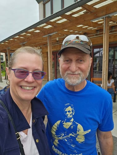 Customer wearing the blue Lincoln 250 T-Shirt while standing next to another person outdoors.
