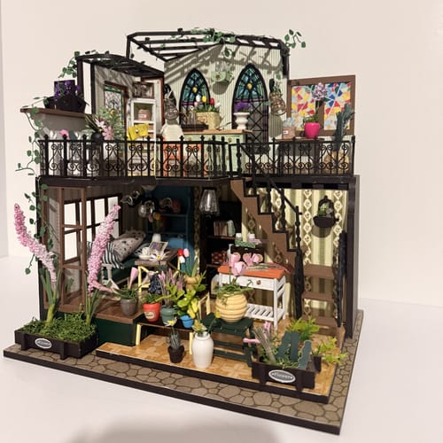 Customer's fully assembled The Flower Loft kit. The detailed two-story model features a balcony and is filled with miniature plants.