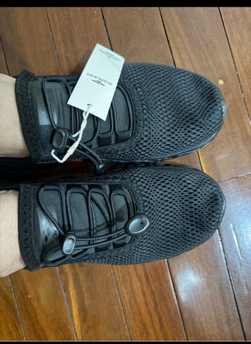 Customer's top-down view of the black mesh Women's Xdrain Crew shoes on their feet, with the tag still attached.