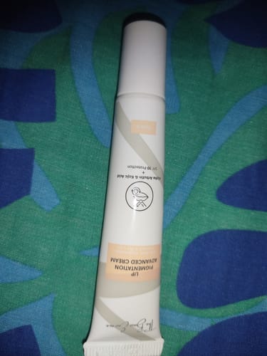 Customer's white tube of Lip Pigmentation Advanced Cream on a patterned background.