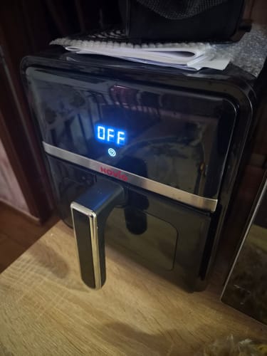 Customer's black Air Fryer Novio StonePro on a wooden surface, with its blue digital display showing 'OFF'.