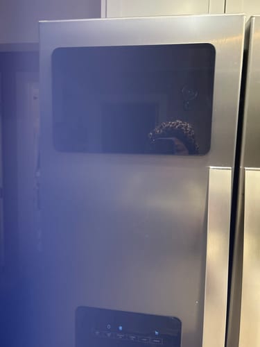 Customer's black FridgeCal calendar mounted on a stainless steel refrigerator.