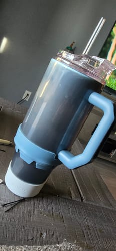 Customer's Opal Sky Thicc Buddy 40oz mug with its light blue handle and band, sitting on a wooden table.
