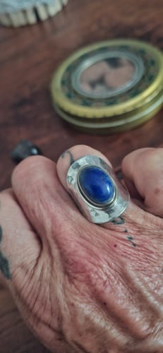 Une cliente porte la Bague Lapis Lazuli Argent, montrant sa large monture en argent et sa pierre bleue ovale.