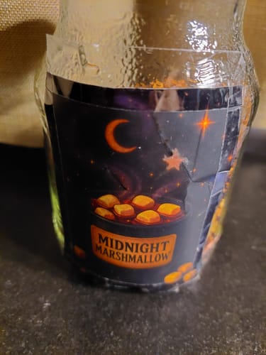 Ein Kunde zeigt den Midnight Marshmallow Tee in einem Vorratsglas, auf das das Produktetikett geklebt ist.