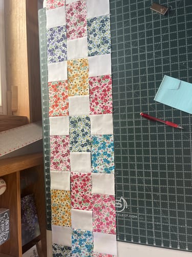 Customer showing their Brick Prairie Precut Quilt Kit partially assembled on a crafting mat.