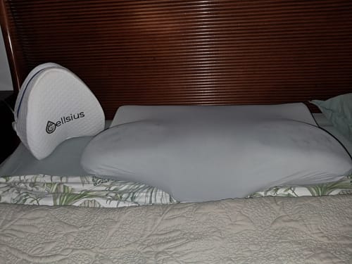 L'oreiller Papillon Cervical Cellsius d'un client sur un lit, à côté d'un autre oreiller Cellsius.