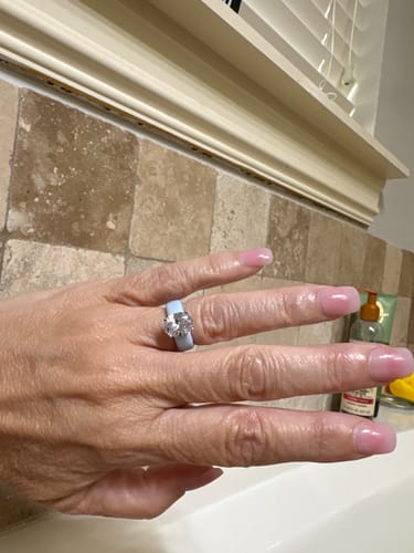 Customer's hand wearing the light blue Silicone Ring with its large, oval-cut CZ stone.