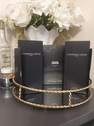 Reviewer's collection of Thomson Carter perfumes, featuring Rouge Avenue, on a decorative gold tray.