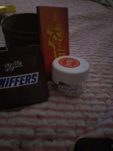Customer's SNIFFERS THCA Flower packaging and other Rollz brand items displayed together on a striped surface.