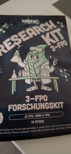 Kunde zeigt die dunkle Verpackung des 3-FPO Forschungskits, die auf einem Tisch liegt.