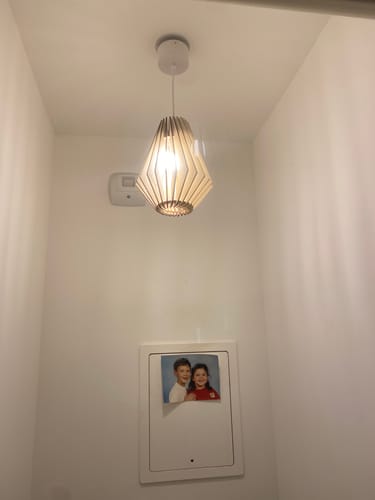 Photo d'un client montrant la suspension Ambre installée dans des toilettes.