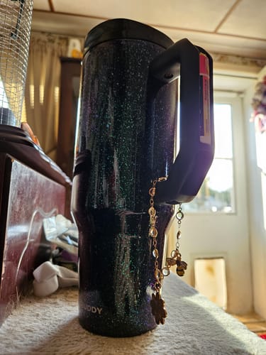 Customer's sparkly Mermaid Thicc Buddy 40oz mug with a chapstick and keychain on its handle.