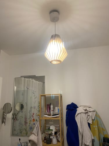 Photo d'un client montrant la suspension Ambre allumée dans une salle de bain.