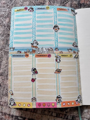Customer's weekly planner layout for late July, decorated with beach-themed penguin stickers from the Ultimate Subscription.
