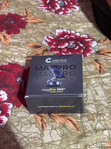 Customer shows the box for the 360° MagPro Magnetic Phone Holder on a floral patterned surface.
