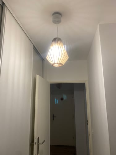 Photo d'un client de la suspension Ambre éclairant un couloir blanc.