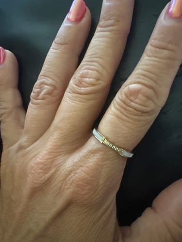 Close-up of a customer wearing the Mother Of Pearl & Crystal Ring, showing its gold band, pearl shell, and crystals.
