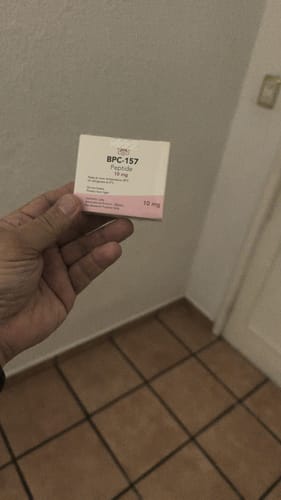 Un cliente sostiene en la mano la caja del producto Péptido BPC-157 de Aesthetic Labs.