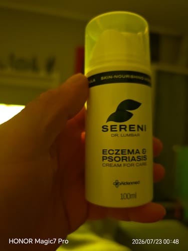 Reviewer holding the white pump bottle of Sereni Eczema & Psoriasis Cream.