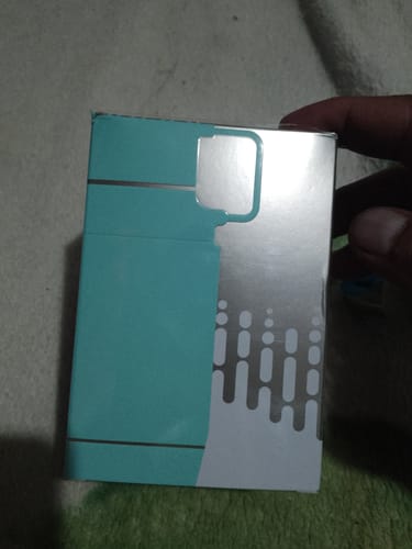 Cliente sostiene la caja turquesa y plateada del perfume ARMAF ODYSSEY AQUA.