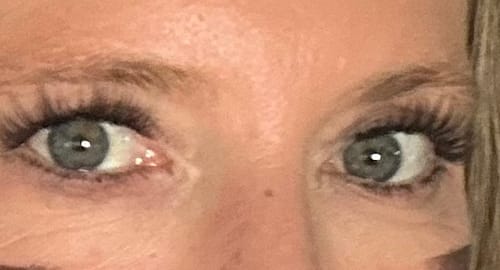 Nahaufnahme der Augen einer Kundin, die die voluminösen Flutter Fling Wimpernverlängerungen trägt.