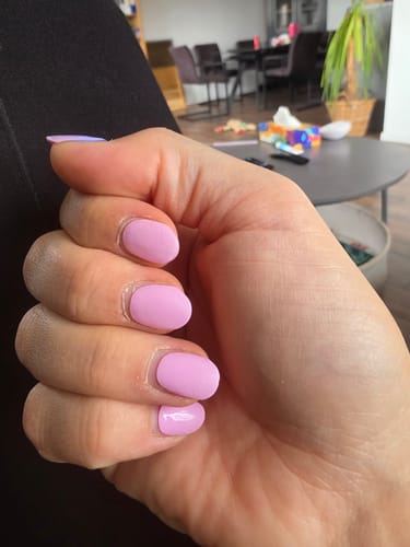 Nahaufnahme der Hand einer Kundin, die die hellrosa UV-Gel-Nagelfolien 'Ballet Pink' trägt.