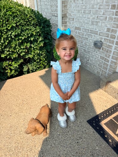 Customer's child wearing the blue Meadow Floral Willow Bubble, which the reviewer says has a nice fit.