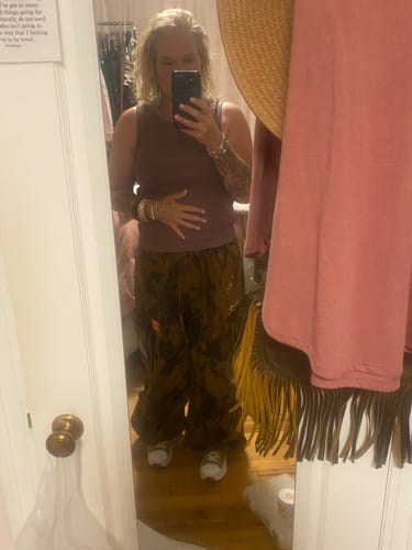 Reviewer wearing the Brown Cow Camo Print Cargo Pants, showing their baggy, oversized fit in a mirror selfie.